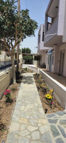a walkway in front of a house with a tree at GLIPTIS Apartments in Karfas