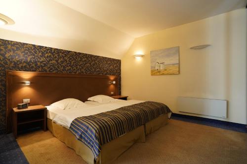a hotel room with a bed and a picture on the wall at Hotel Watermolen Le Mirage in Kasterlee