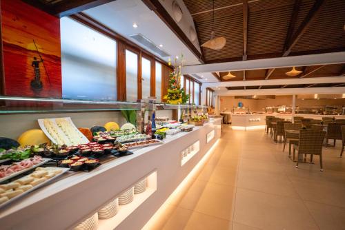 a buffet line with food on display in a restaurant at HL Miraflor Suites Hotel in Playa del Ingles