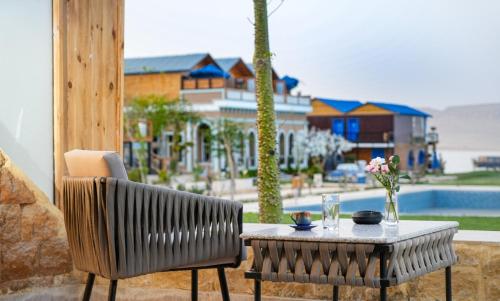 a table and a chair on a patio with a view of a pool at venecia Resort Fayoum in Al Ḩammām