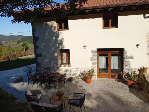 a house with a table and chairs in front of it at Belaustegi turismo rural in Ispáster