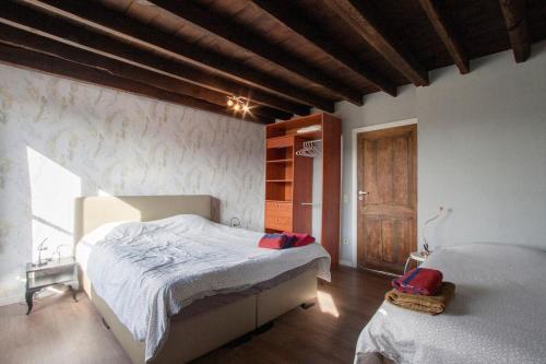 a bedroom with a large bed and a window at Holidayhouse Balie in Bruges