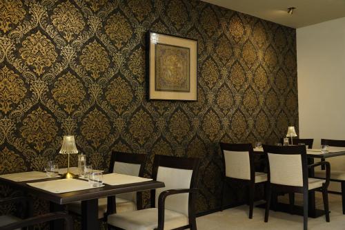 a dining room with tables and chairs and a wall at Hotel Watermolen Le Mirage in Kasterlee