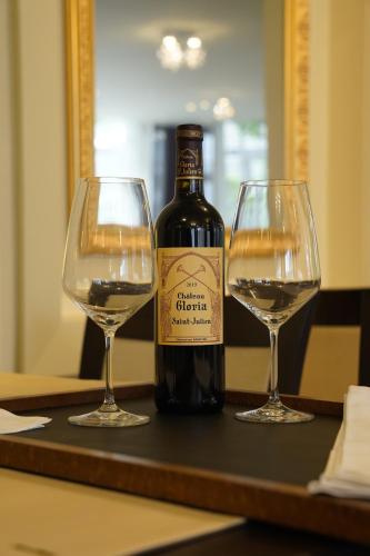 a bottle of wine and two glasses on a table at Hotel Watermolen Le Mirage in Kasterlee