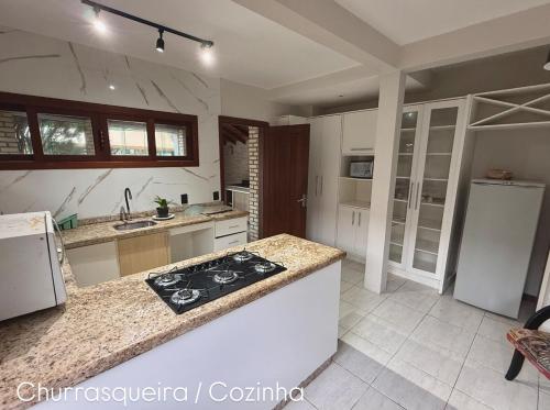 a kitchen with a stove top oven next to a counter at Pousada Ilha do Sol in Florianópolis