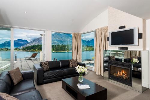 a living room with a couch and a fireplace at Oaks Queenstown Club Suites in Queenstown