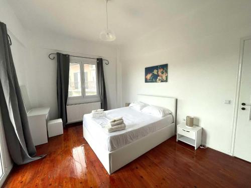 a bedroom with a white bed and a wooden floor at Live the Summer Dream at Gaios Cozy Retreat in Gaios
