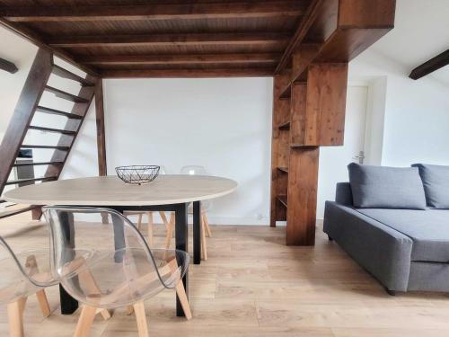 une salle à manger avec une table et un canapé dans l'établissement Le Vivaldi Prox Centre Ville et Place Stan, à Nancy