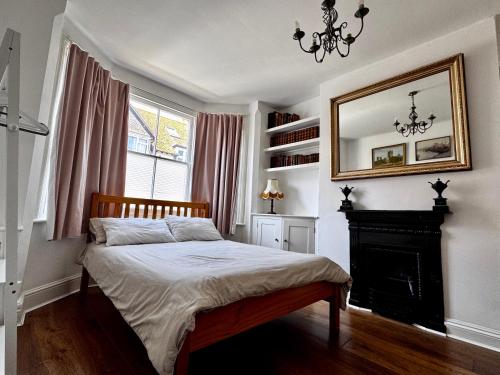 a bedroom with a bed with a fireplace and a mirror at Cozy Place in Oxford