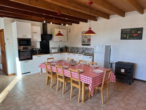 une cuisine avec une table et des chaises dans une pièce dans l'établissement Les Volets Bleus, à Saint-Saviol
