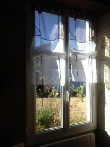 une fenêtre ouverte avec vue sur la cour dans l'établissement Les Volets Bleus, à Saint-Saviol