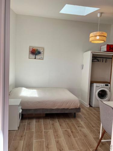 - une petite chambre avec un lit et un lave-linge/sèche-linge dans l'établissement Petite maison de ville Matabiau Jean Jaurès, à Toulouse
