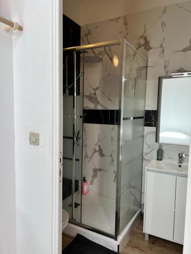 une salle de bain avec une douche en verre et un lavabo dans l'établissement Petite maison de ville Matabiau Jean Jaurès, à Toulouse