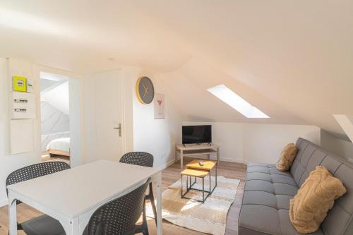 a living room with a couch and a table at Le Toit Rayonnant in Le Havre