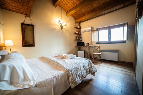 a bedroom with a bed and a desk in it at Boscoscuro in Ragalna