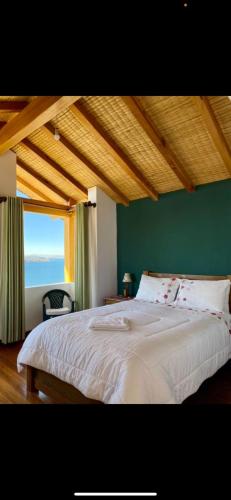a bedroom with a large bed with a large window at Casa de la Luna in Comunidad Yumani