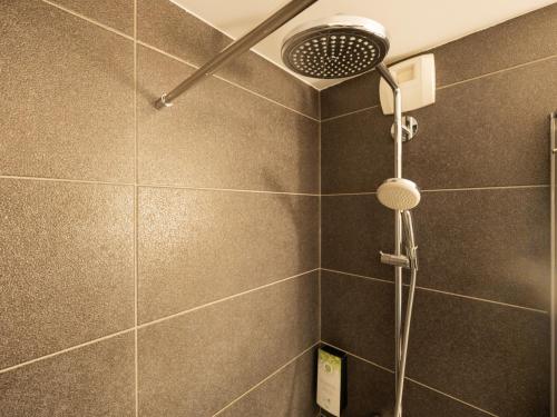 a shower with a shower head in a bathroom at Campanile Hotel & Restaurant Amsterdam Zuid-Oost in Amsterdam