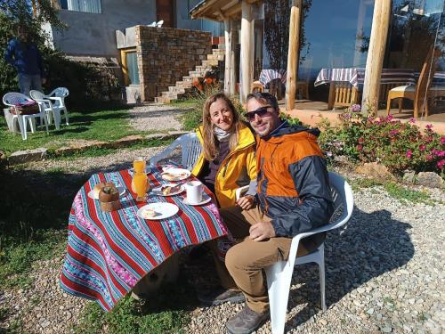 a man and a woman sitting at a table at Casa de la Luna in Comunidad Yumani