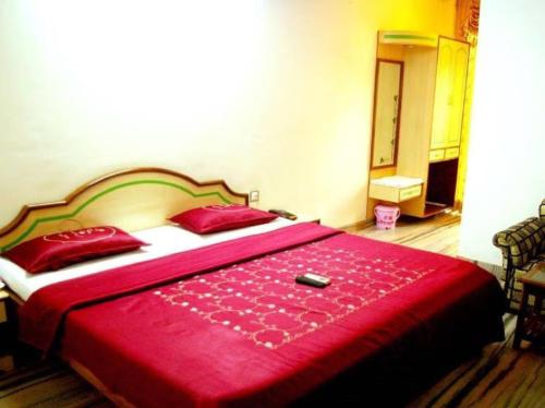 a bedroom with a red bed with a red blanket at AGRA HOTEL VIREN SOFYTEL - Near Taj Mahal And Park# - Free Wi-fi And Parking Facilities - A Premium Hotel In Agra in Agra