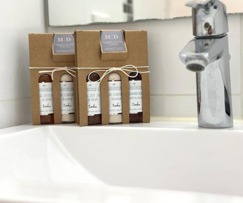 4 bouteilles de vin assises sur un comptoir à côté d'un évier dans l'établissement Elegant T3 vue mer, à Capbreton