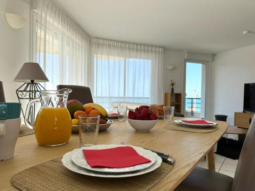 - une table à manger avec des fruits et des jus de fruits dans l'établissement Elegant T3 vue mer, à Capbreton