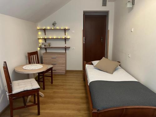 a bedroom with a bed and a table and a table and chair at Domek w Lesie in Karłów