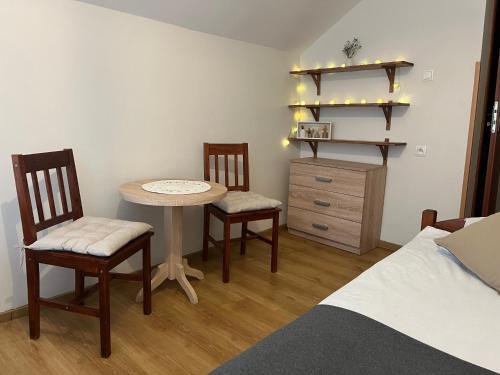 a bedroom with a table and two chairs and a bed at Domek w Lesie in Karłów
