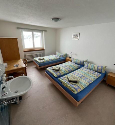 a room with two beds and a sink in it at Hospezi Santa Maria in Platta