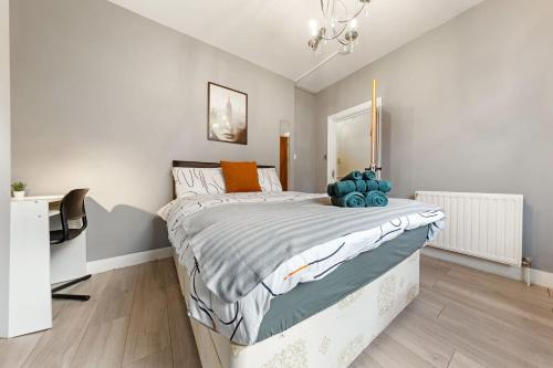 a bedroom with a bed and a desk in it at Lord’s Guesthouse - Room 2 in London