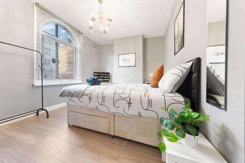 a bedroom with a large bed and a chandelier at Lord’s Guesthouse - Room 2 in London