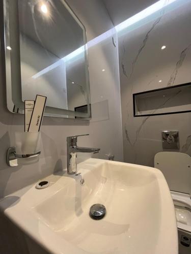 a bathroom with a white sink and a mirror at Menzal-202 in Al Madinah