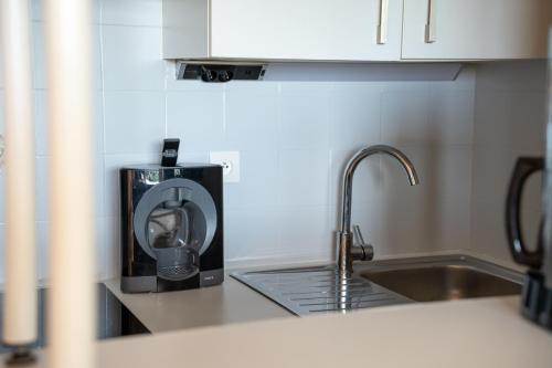 Il comprend une cuisine équipée d'un grille-pain et d'un évier. dans l'établissement Alora - Superbe Studio Vue Mer Climatisé avec Piscine, à Cavalaire-sur-Mer