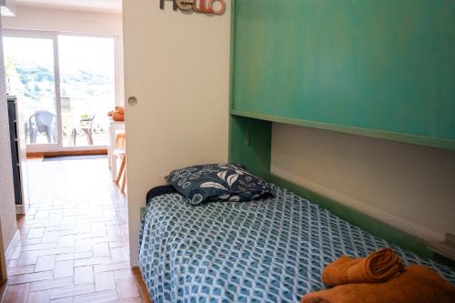- une chambre dotée d'un lit avec un mur vert dans l'établissement Alora - Superbe Studio Vue Mer Climatisé avec Piscine, à Cavalaire-sur-Mer
