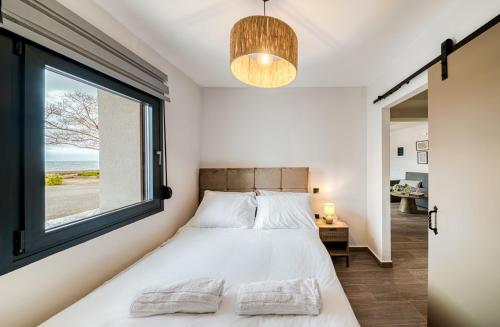 a bedroom with a bed and a large window at Windmill Escape Apartments B in Chios