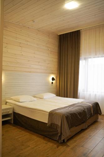 a bedroom with a large bed in front of a window at Sunrise Hotel in Kyiv