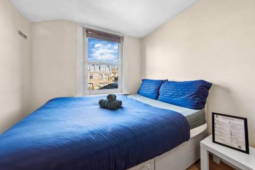 a small bedroom with a teddy bear sitting on a bed at Lord’s Guesthouse - Room 3 in London