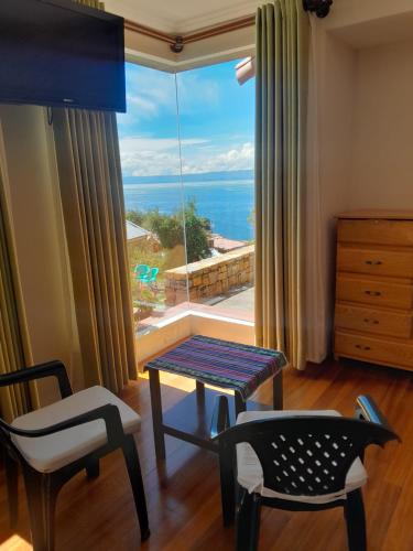 a room with a table and chairs and a large window at Casa de la Luna in Comunidad Yumani