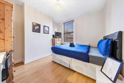 a bedroom with a blue bed and a desk at Lord's Guesthouse - Room 4 in London