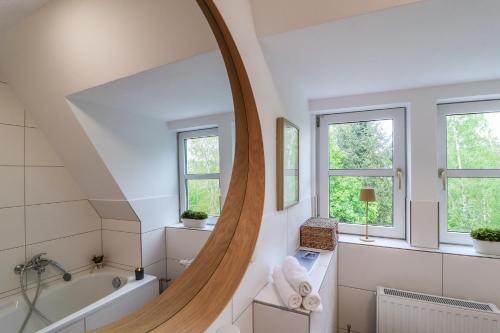 a bathroom with a large round mirror and a tub at ErzGlück Apartment I WLAN I Küche I Stellplatz I 4P in Neuwelt