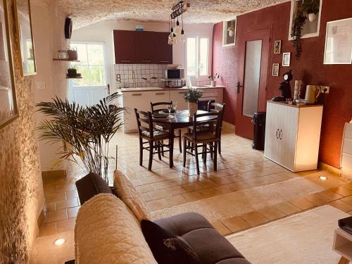 uma sala de estar e cozinha com mesa e cadeiras em "Ninho de Amor" troglodyte unique em Montrichard