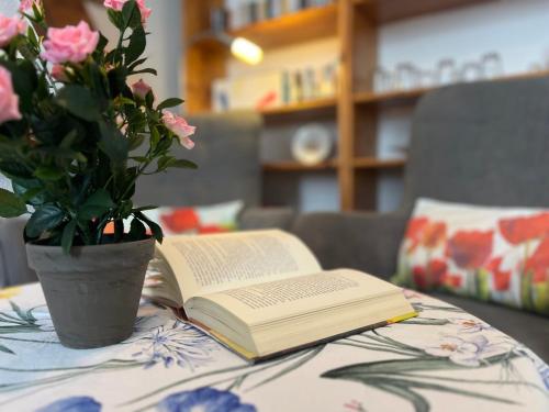 a book and a vase of flowers on a table at Dünenmeisterei Whg "Tulpe" in Ostseebad Koserow