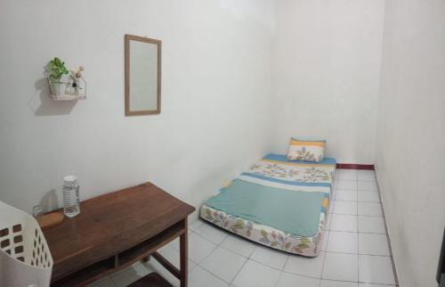 a small bedroom with a bed and a table at Bantul Syariah Homestay in Bantul