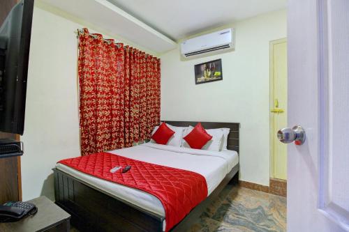 a bedroom with a bed with a red curtain at Hotel O India Gate in Chennai