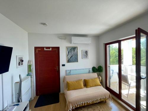 a living room with a couch and a red door at Sara Brela Apartment in Brela