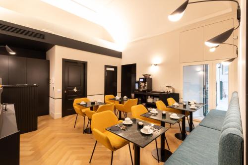 a dining room with tables and yellow chairs at Relais Ammira in Naples