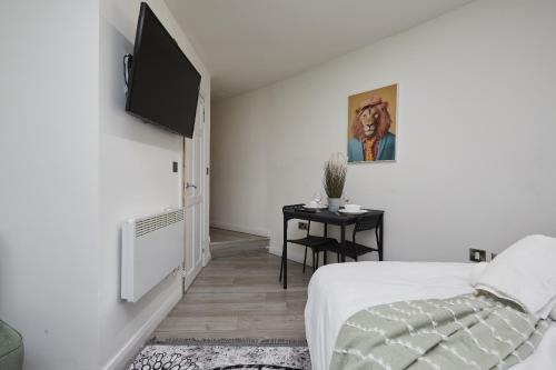 a bedroom with a bed and a television on a wall at Hayy Vibrant Studios Queensgate in Huddersfield