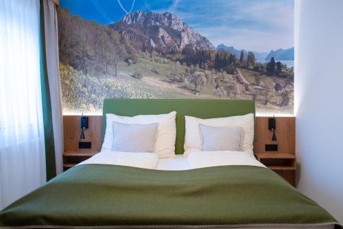 a bedroom with a large bed with a painting on the wall at Gasthof Engelhof in Gmunden