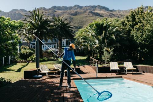 a person isaining a pool with a tennis racket at Bloemenzee Boutique B&B in Gordonʼs Bay