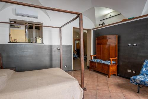a bedroom with a canopy bed and a chair at lovingenoa Natural - Light in Genoa