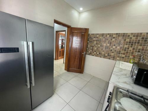 a kitchen with a stainless steel refrigerator and a sink at Dakar logement 221 in Dakan
